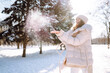 © maxbelchenko - Winter smiling woman stands among snowy trees in winter forest.