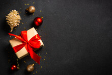 Christmas Flat Lay Background. Present Box And Holiday Decorations On Black. Top View With Space For Design.