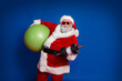 © deagreez - Photo of handsome strong santa claus wear red costume hat dark holding fitball building muscles isolated red color background