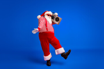 Poster - Full length body size view of his he handsome bearded fat overweight cheery Santa listening pop carrying tape player dancing having fun isolated bright vivid shine vibrant red color background