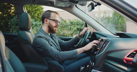 Side view of caucasian businessman making scrolling and typing text on touch screen monitor on car.
