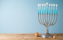 Jewish Holiday Hanukkah Background With Menorah And Candles On Wooden Table.