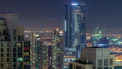 Wall Mural - Dubai downtown and business bay day to night transition timelapse, illuminated luxury modern buildings, futuristic cityscape of United Arab Emirates. Aerial top view from skyscraper after sunset