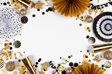 Aufkleber - New Years Eve frame of gold and black confetti, noisemakers, streamers and decorations. Above view on a white background.