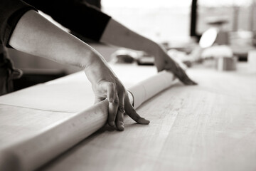 Close up of female hands working with rolling-pin for italian fresh pasta -  Female hands rolling  for fresh dough on the wooden table - concept of cooking and fresh homemade pasta - retro style