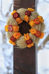 Poster - A beautiful wreath made of dry plants is hanging on a porch.