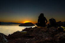 A Seated Person In Silhouette At Sunrise On A Rocky Outcrop Looks Out Over The Bahía Concepción, Sea Of Cortez, Baja De California Sur, Mexico