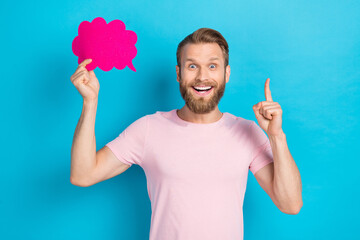 Wall Mural - Photo of funny excited young man wear pink t-shirt pointing finger holding mind cloud isolated blue color background