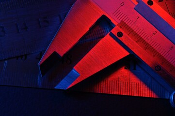 Wall Mural - caliper and metal rulers illuminated in red and blue. close-up