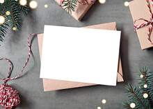 Blank White Paper Card With Brown Envelop, Christmas Pine And Handmade Gift Box On Grey Background.