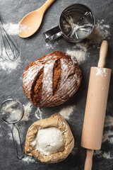 Poster - Whole loaf of fresh homemade bread with ingredients for cooking on the table in the bakery top view
