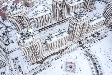 Wall Mural - winter city scenery. snow-covered apartment buildings, rooftops, courtyards with parked cars. aerial overhead view.