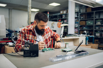 Electronics engineer working in a workshop with tin soldering parts