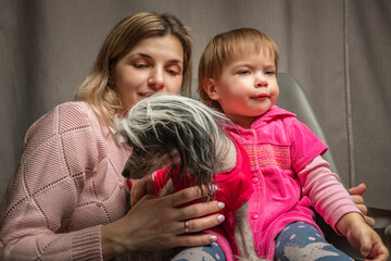 A beautiful young mother with a little daughter is photographed in a home studio.