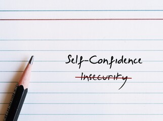 Pencil writing on note paper INSECURITY, replaced with SELF CONFIDENCE - to overcome being insecure and build feeling of trust in self abilities and belief