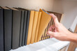 © zephyr_p - Male hand choosing and picking brown book on wooden bookshelf in public library. Education research and self learning in university life concepts