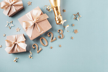 Wall Mural - Golden gift or present boxes, 2023 numbers and Christmas decorations on blue turquoise background top view. Flat lay composition for New Year.