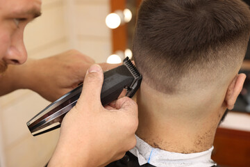 Canvas Print - Professional hairdresser working with client in barbershop, closeup