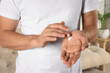 © New Africa - Man applying cream onto hand at home, closeup
