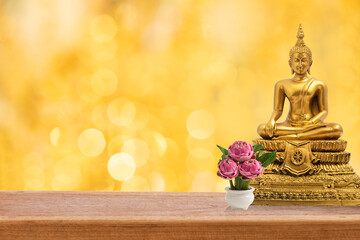 Wall Mural - Buddha on wood floor and on golden bokeh background.