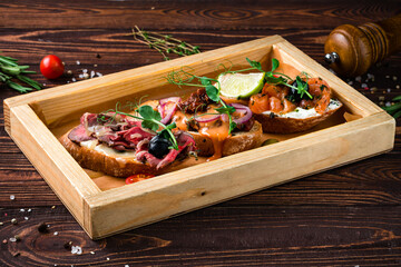 Wall Mural - Assorted bruschetta with salmon, beef cut, sun-dried tomatoes, onion, mushrooms, cream cheese and baguette.