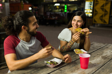 Wall Mural - Attractive couple eating mexican tacos from the food truck