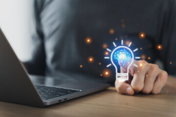 Businessman working or student studying and holding bright lightbulb. Business or education success or growth idea concept, creativity and strategy thinking, online knowledge and cognition learning