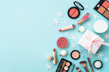 Poster - Winter cosmetic with present box and holiday decorations on blue. Christmas sale and gift concept. Flat lay with copy space.