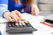 © spyrakot - Close up young woman using calculator, managing household monthly budget