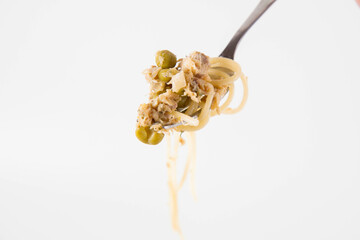 Sticker - Spaghetti with smoked mackerel and green peas cream sauce on a white background rolled around a fork