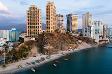 Highrise Apartment Buildings On Colombia's Caribbean Coastline With Colorful Boats On The Beach