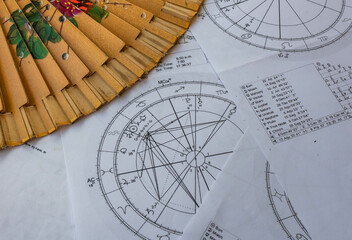 Wall Mural - Printed astrology charts with a japanese fan in the background