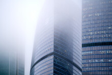 Windows Of Skyscrapers In The Fog, Background Copy Space. Metal Structures With Windows Of A High-rise Building In Smog, Close-up