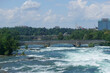 Niagara Falls, NY: Tourists on the Pedestrian Bridge to Goat Island, over the  American rapids. The Canadian side of the gorge is in the background.