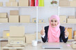 Active asian woman in blue muslim suit sitting and working with computer and online package box delivery. Startup small business freelance working girl showing thumb up with exciting emotion.