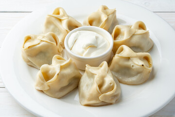 Wall Mural - Russian meat dumplings with sour cream on white plate