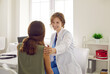 © Studio Romantic - Friendly doctor in a white coat supporting a teenage child. Happy beautiful young woman who works as a pediatrician at the clinic talks to a school girl, reassures her, smiles and touches her shoulder