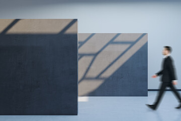 Aufkleber - Side view of blurry male walking in spacious gallery interior with empty poster and sunlight shadow on concrete wall. Mock up.