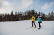 © Halfpoint - Senior couple skiing together in the middle of forest.