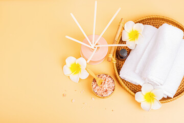 Poster - Spa massage Aromatherapy body care background. Spa herbal balls, cosmetics, towel and tropical leaves on orange table. Top view, flat lay, overhead, copy space. Beauty and health care concept