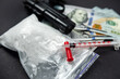drug heroin lies next to syringes, money dollars weapons isolated on a dark background.
