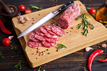 Wall Mural - Traditional salami sausage on wooden cutting board with spices