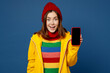 © ViDi Studio - Young woman in sweater hat yellow waterproof raincoat outerwear hold use mobile cell phone blank screen area isolated on plain dark royal navy blue background Outdoor wet fall weather season concept