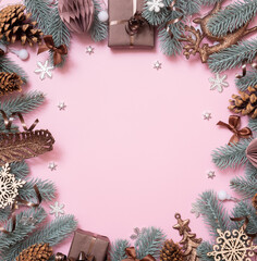 Wall Mural - Frame made frome pine tree branches and Christmas decoration on colored background with copy space