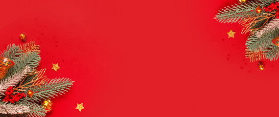 Wall Mural - Christmas decoration and pine tree on red background with copy space. New Year greeting card. Flat lay