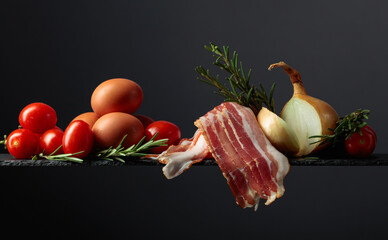 Wall Mural - Smoked bacon with eggs, tomatoes, onions and rosemary.