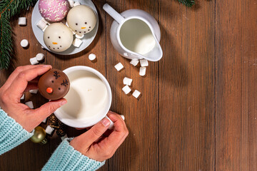 Wall Mural - Making winter hot drink, preparation funny Christmas characters with hot chocolate bomb. Homemade hot chocolate cocoa balls made with Christmas snowman, reindeer, snowflake decor