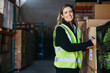 © Jacob Lund - Female warehouse worker smiling at the camera happily