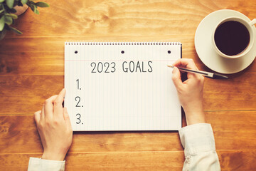 Aufkleber - 2023 goals with a person holding a pen on a wooden desk