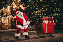 Full Length Portrait Of Grandfather Santa Claus Costume Pull Pile Stack Newyear Giftbox Sled Tree Lights Decor Outside